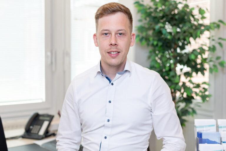 Jasper Umlandt. Er ist stellvertretender Leiter in der Technik der Wohnstätte Stade eG. Herr Umlandt ist mittleren Alters, hat einen hellbraunen Kurzhaarschnitt und trägt ein weißes Hemd.