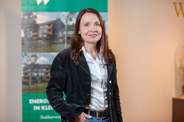 Britta Teichert. Sie ist Mitarbeiterin im Bereich Kundenbetreuung der Wohnstätte Stade eG. Frau Teichert ist mittleren Alters, hat Dekolleté-lange, braune Haare und trägt ein weißes Hemd mit einer schwarzen Jeansjacke.